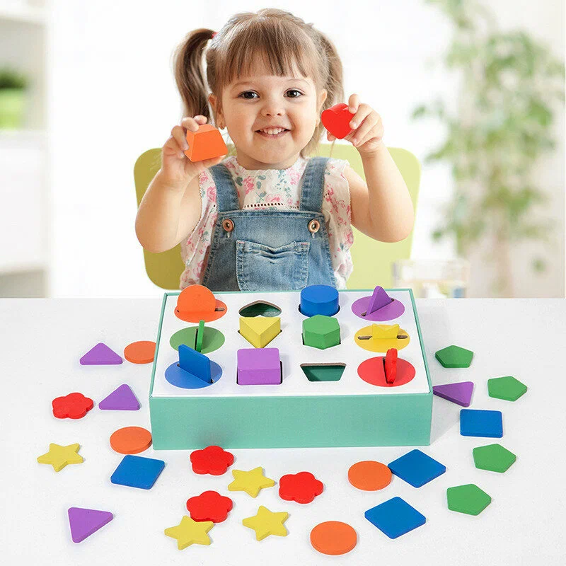 Toddler solving a geometric shape sorter wooden puzzle box concentrating on shape matching