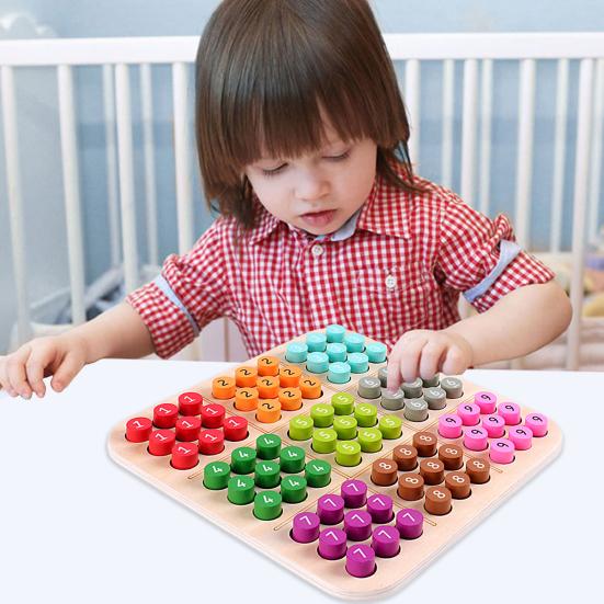Toddler practicing fine motor skills with wooden peg board and precision pincer grip on colorful wooden pegs