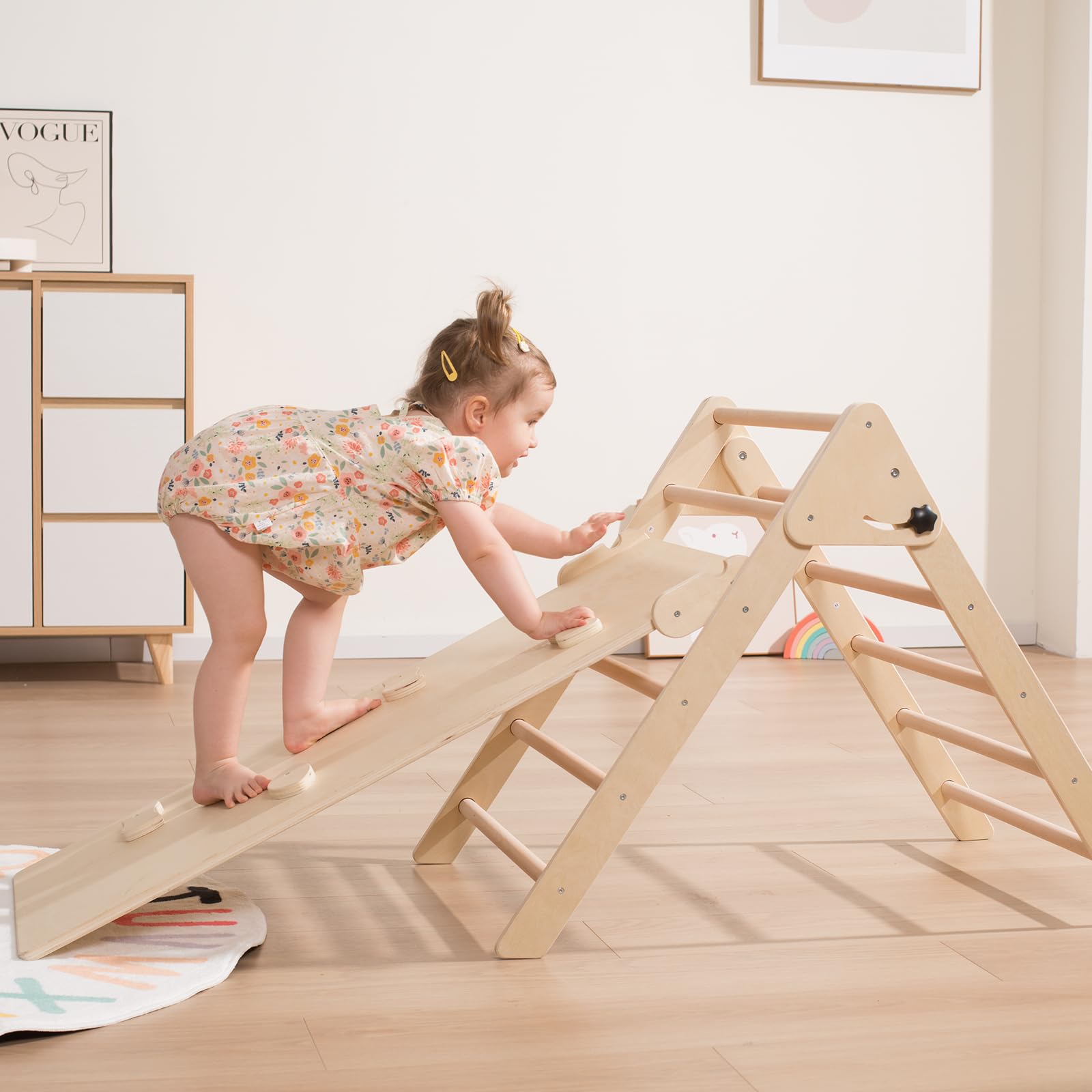 Active toddler climbing on a wooden Pikler triangle climbing arch indoor wooden play structure