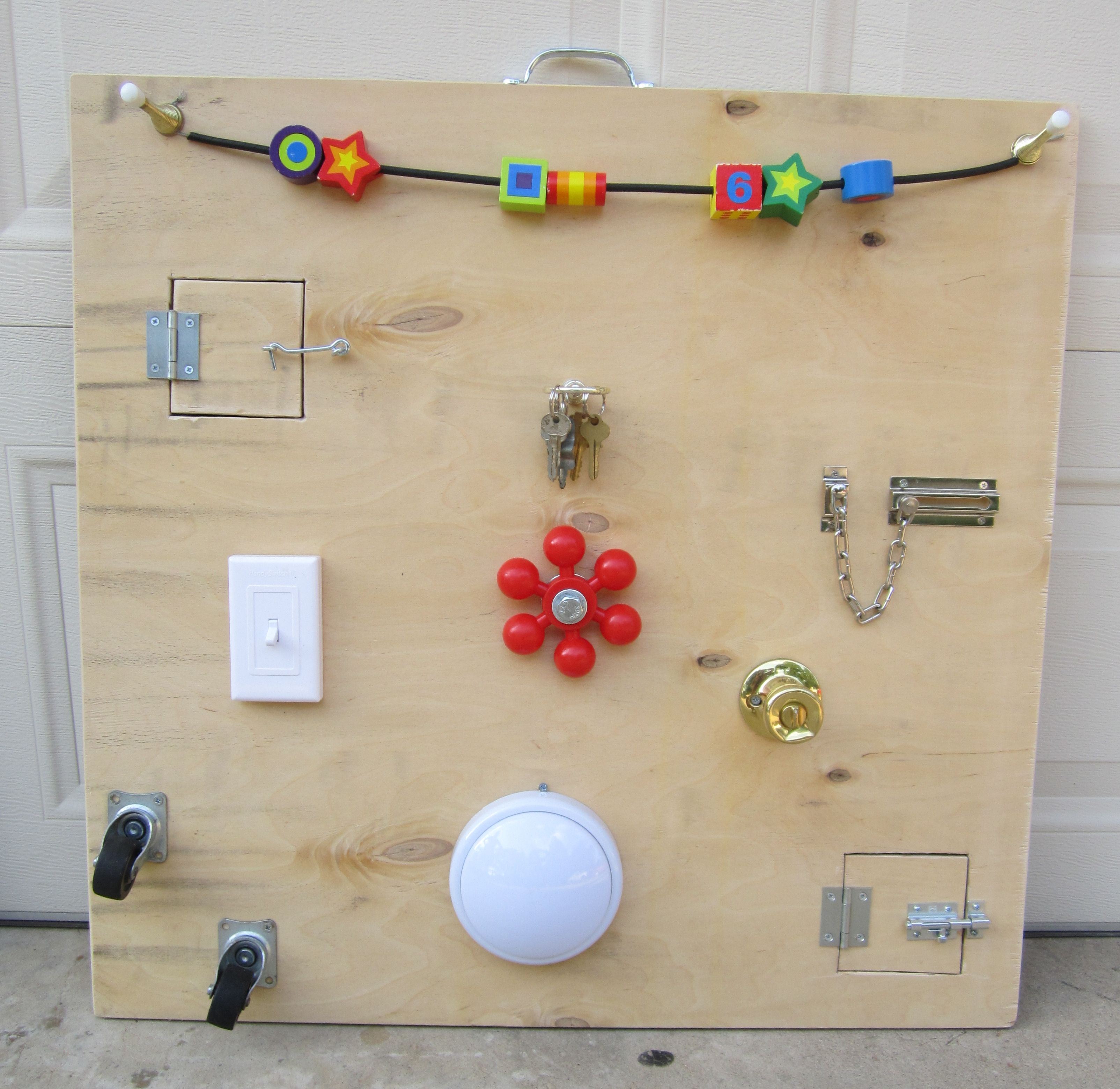 Wooden Montessori busy board with locks latches and doors